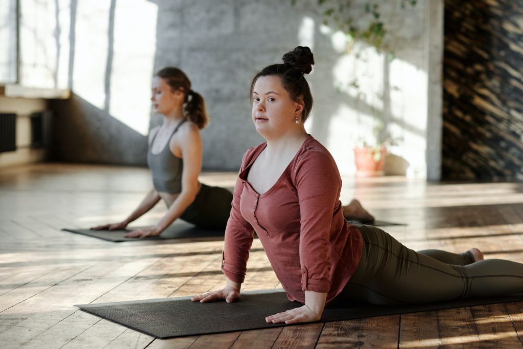 Behinderte und nicht-behinderte Menschen machen gemeinsam Yoga.