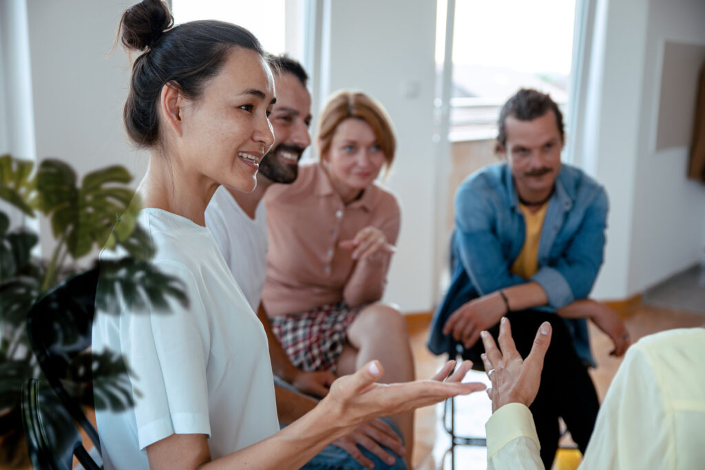 Ein gut gelauntes Team sitzt zusammen in einer Gesprächsrunde und diskutiert miteinander.